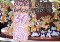 'Score below 30 to win' sign at fairground stall.